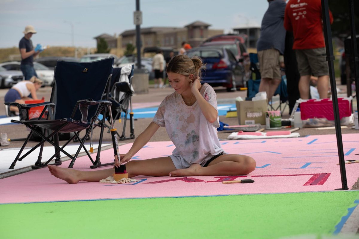 Sophia Huddleston painting her senior parking spot. Photo by Lana Miller (Yearbook).
