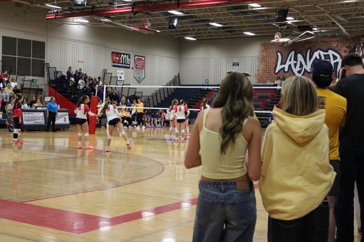 Libert student section dressed in yellow gear at the Sept. 25 volleyball game. Photo by Bella Howard.