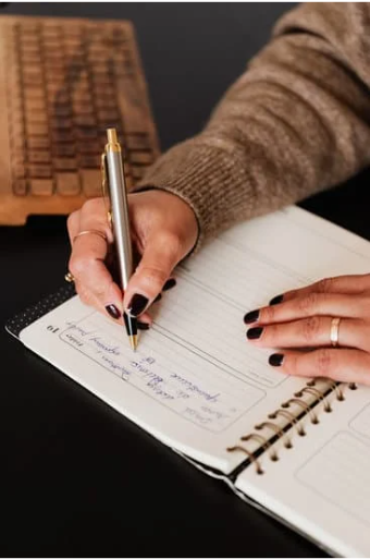 Student writing in their planner. Photo from Canva.com.