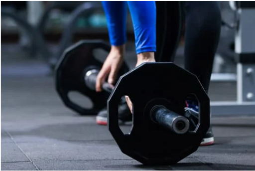A person lifting a weight in the gym. Photo from Canva.com.