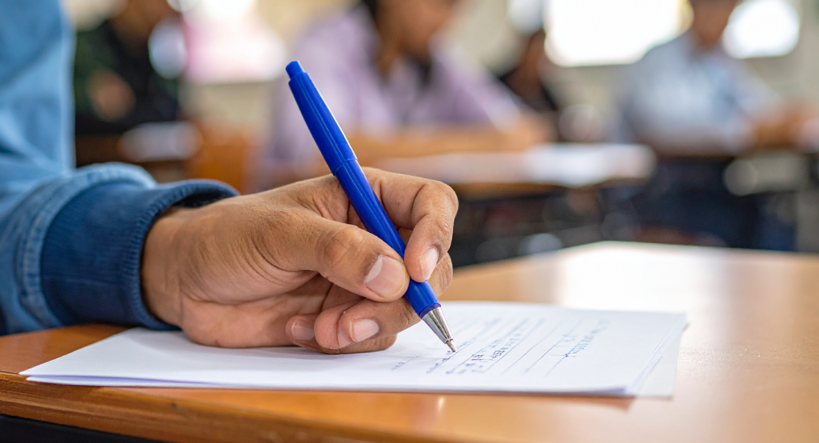 A person writing on a test. Photo from Canva.com.