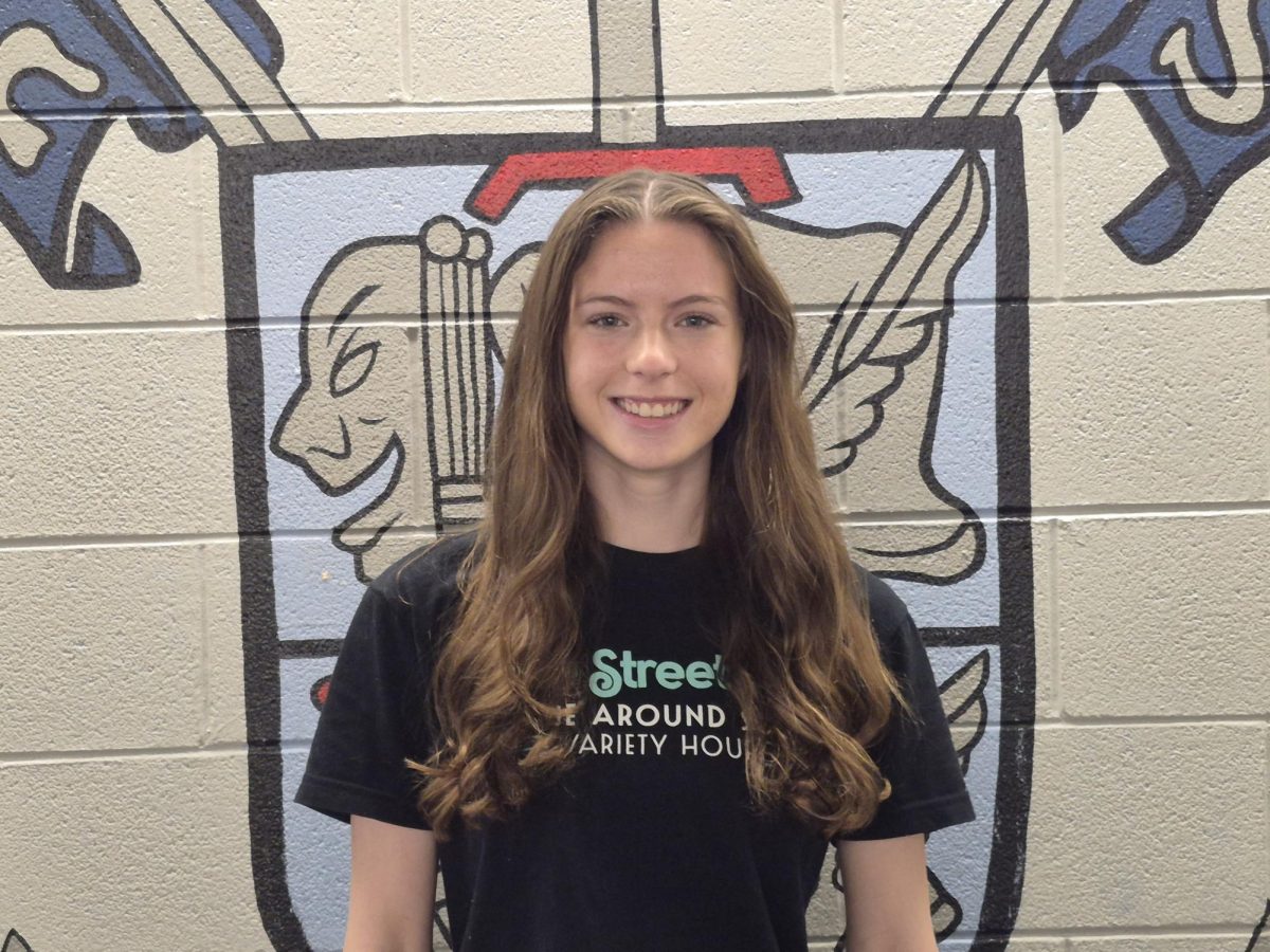 Class of 2026 Valedictorian Siobhan Patterson in front of the Liberty crest. Photo by Aspen Laslie. 