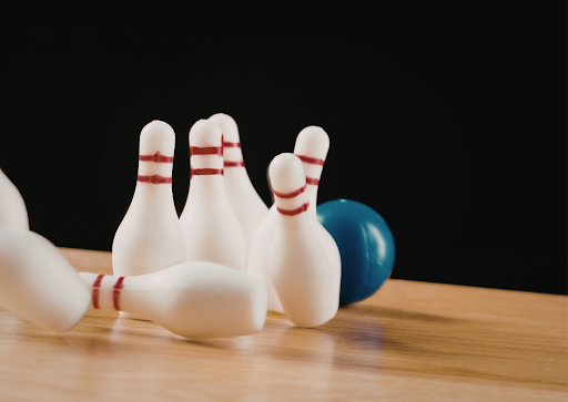 Bowling ball knocking down bowling pins. Photo courtesy of Canva.com.