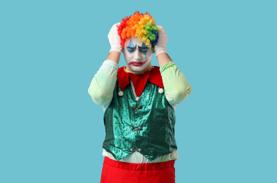 A clown holding his head. Photo from Canva.com.
