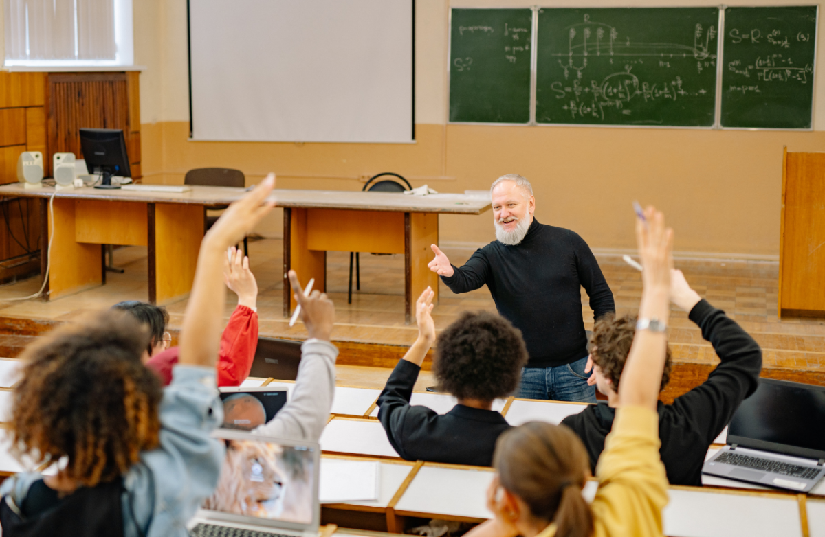A teacher in a classroom with students. Photo by Canva.com.